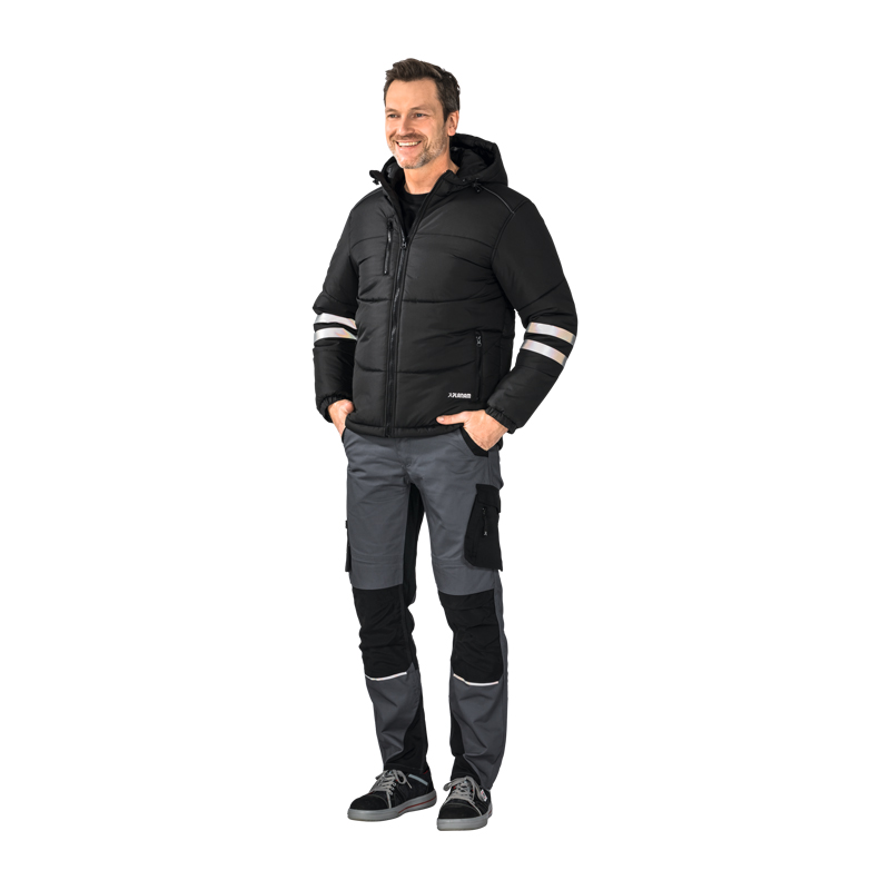 Model trägt die Planam Craft Jacke gefüttert mit Reflexstreifen in Schwarz, warme Arbeitsjacke mit Kapuze und reflektierenden Streifen an den Ärmeln.